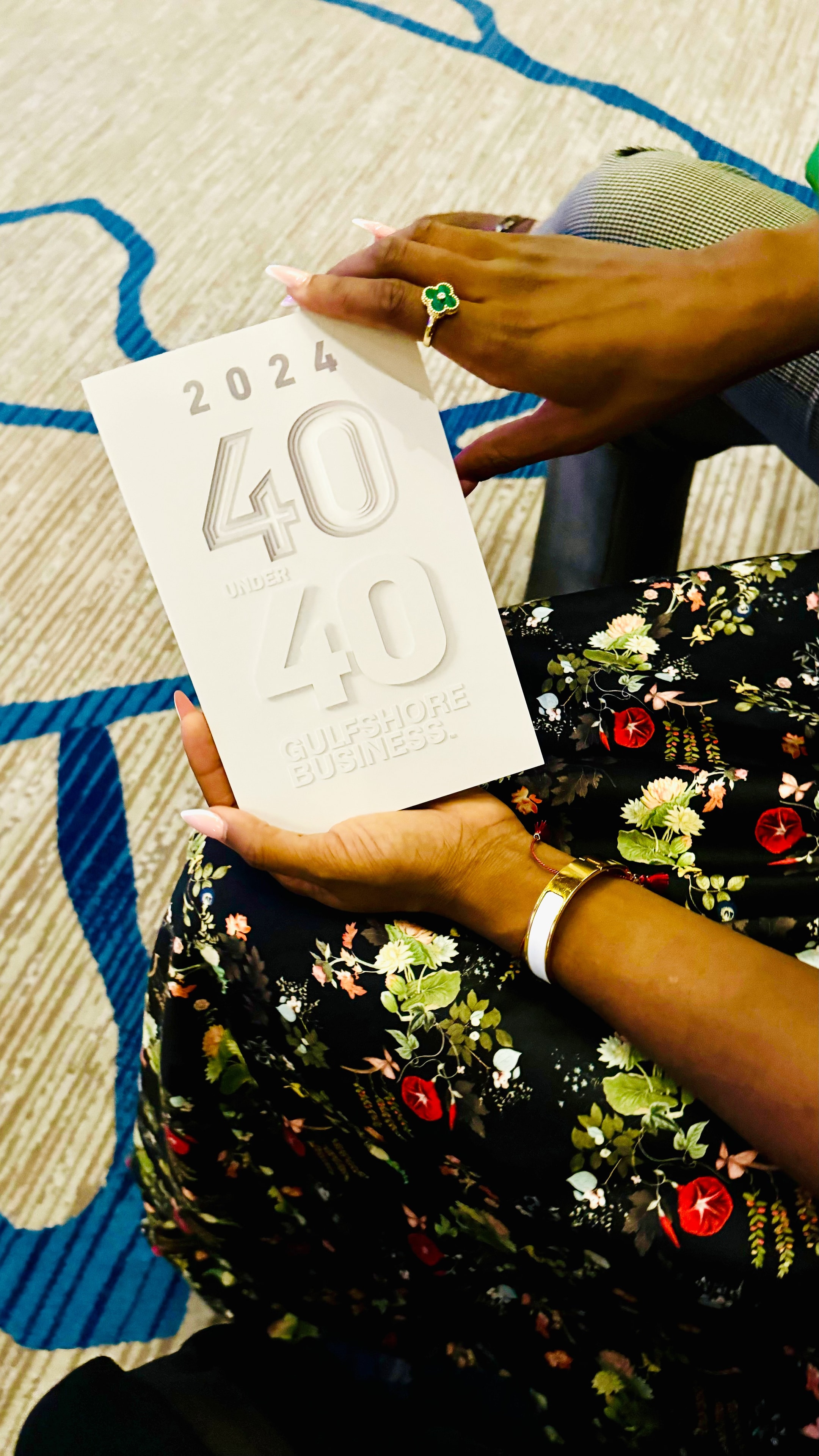 Dr. Deborah Houk holding the 2024 Gulfshore Business 40 Under 40 award booklet